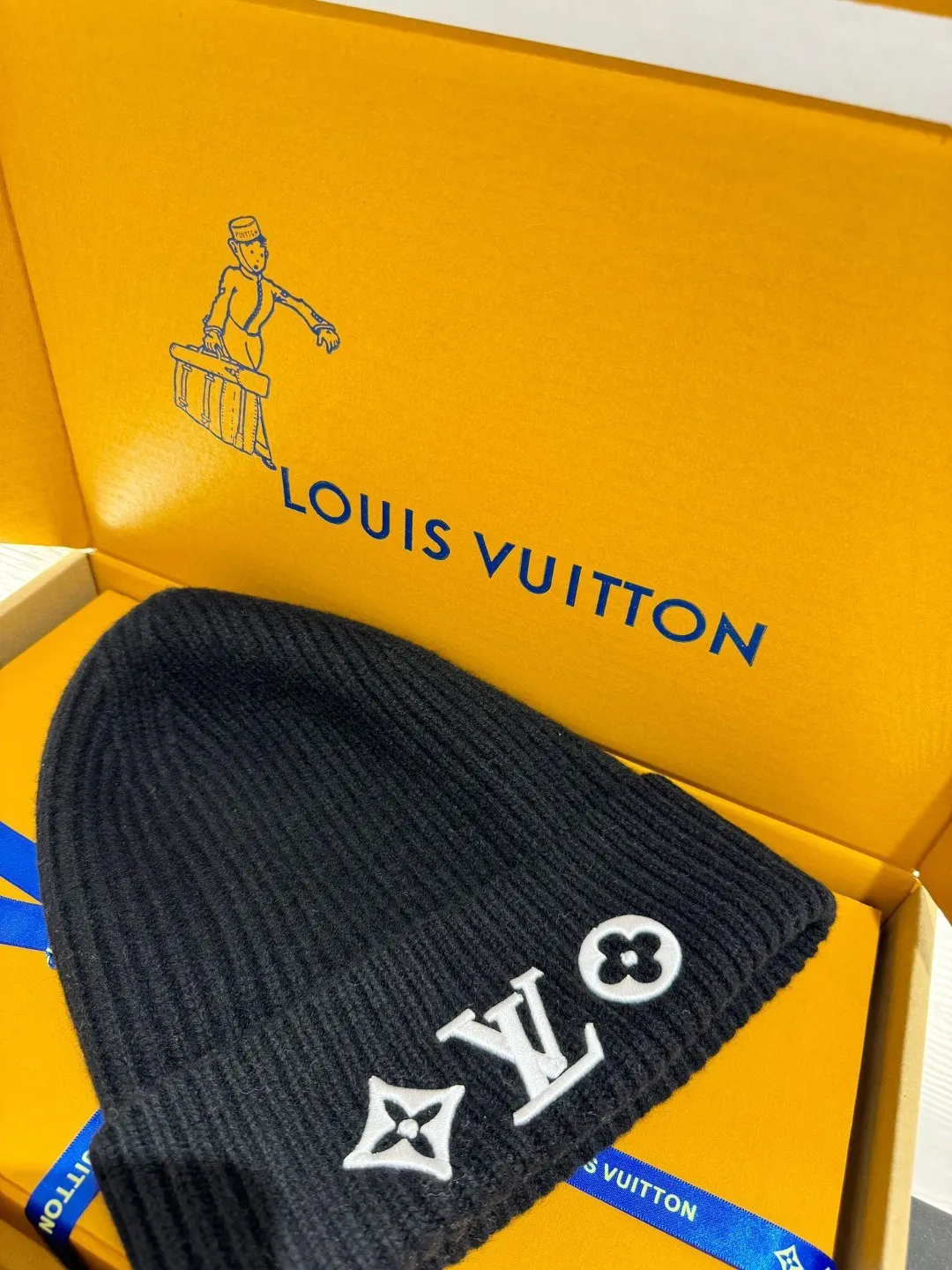 LOUIS VUITTON new embroidered wool cold hat ●Original version: 3800 purchase and development ●Item number: 1681973-A45 ●Fabric: wool blended fabric ●Technology: embroidery production ●Color: white/black ●Version: fitted version ●Description: This is LV The 2025 autumn and winter series logo embroidered knitted cold hat is made of 100% Italian virgin wool, woven with a 30-needle dense weaving process. The yarn twist reaches 600 twists/meter, which has both warmth and stiffness. The main body of the hat has a vertical grooved texture, which is elastically wrapped through fixed-spacing stitching techniques. The front logo of the hat uses three-dimensional appliqué technology, and the Monogram elements (quatrefoil, LV letters) are sewn with high-density embroidery threads of the same color. The edges are overlocked to prevent fuzzing and threading; the top of the hat is made of double-layer ribbing, which is durable and elastic and fits the ears. The finished product is shaped by high-temperature steam, and the three-dimensional shape of the hat is not easily deformed. The post-finishing process includes anti-static treatment, making it more comfortable for daily wear. The lining of the packaging is printed with the brand's classic "luggage maker" pattern, continuing the brand's retro luxury tone. The overall wiring is straight and delicate, the fabric is comfortable and soft, and the color is consistent without color difference. It can be matched with the same style to create a fashionable look and control various occasions. Customized accessories, complete with three standards, same style for men and women!